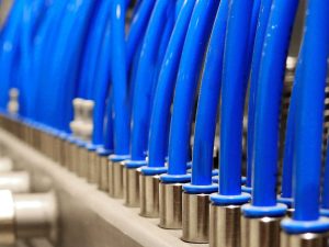 Close-up shot of blue pneumatic tubes in a manifold in an industrial setting