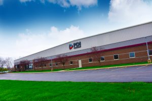 Power Drives, Inc. headquarters and manufacturing facility in Buffalo, NY on a sunny day with a blue sky