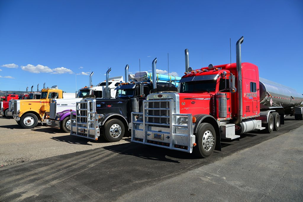 A row of heavy duty diesel engine trucks in a parking lot